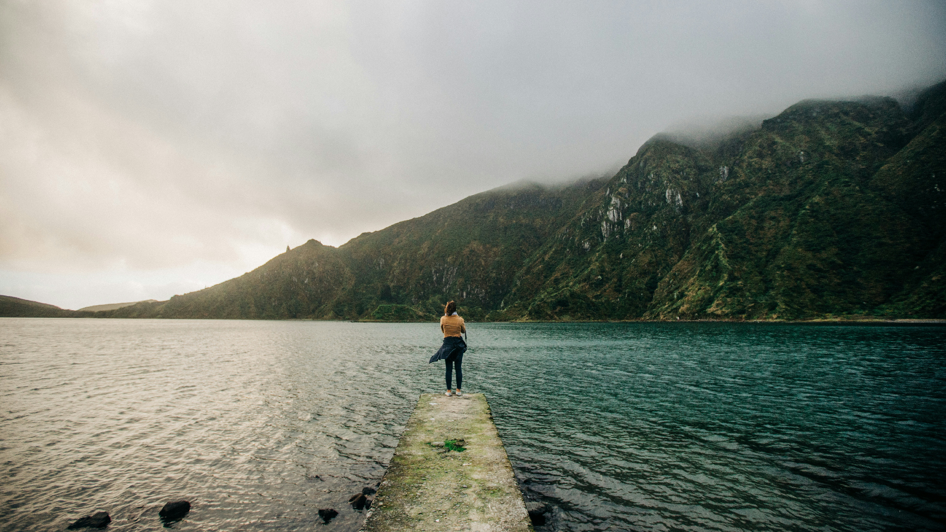Uma mulher diante da imensidão da Lagoa do Fogo numa viagem aos Açores